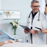 Doktor ve hemşirenin hastane odasında bir hastayı ziyaret ettiği an